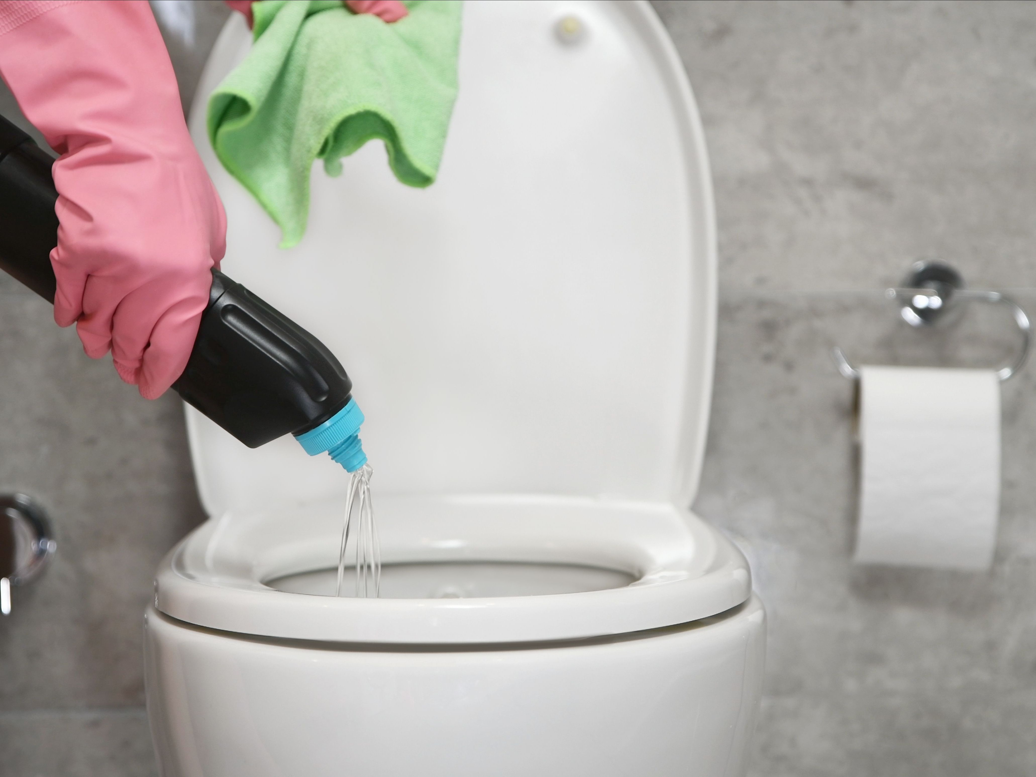 toilet cleaner being poured into toilet