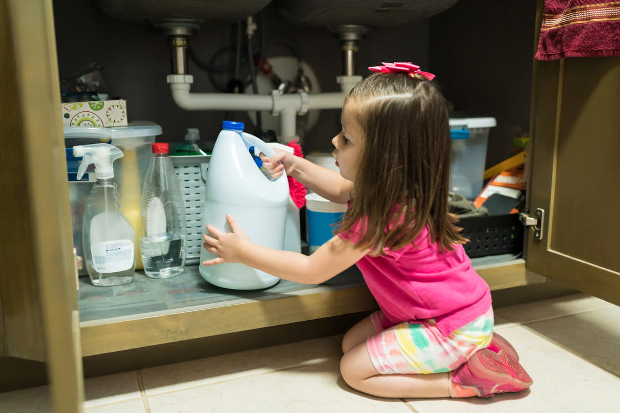 child grabbing bleach bottle from cabinet