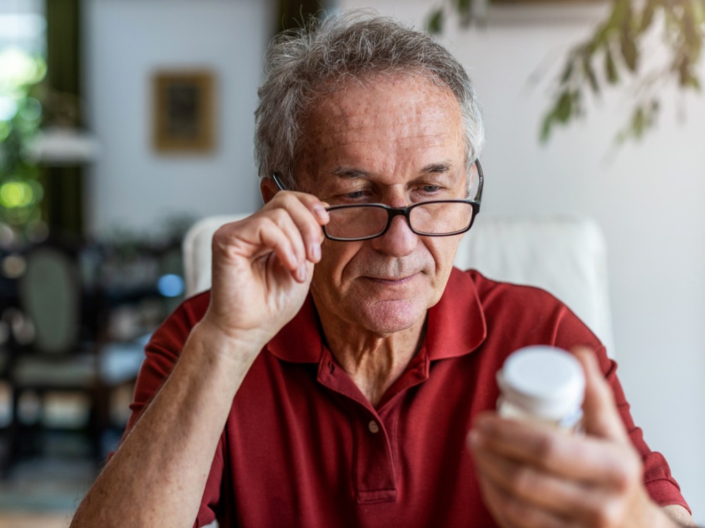 man reading medicine bottle