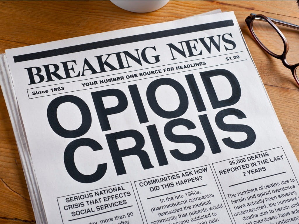 opioid crisis newspaper headline on desk