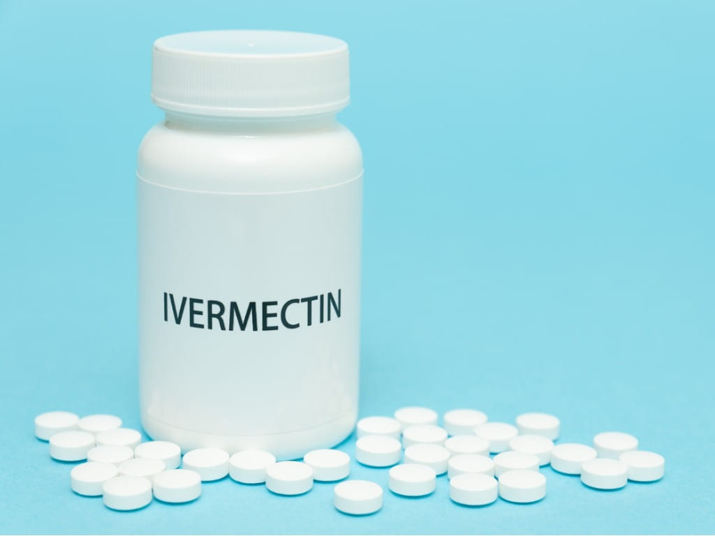 Bottle labeled "Ivermectin" with white pills on blue background