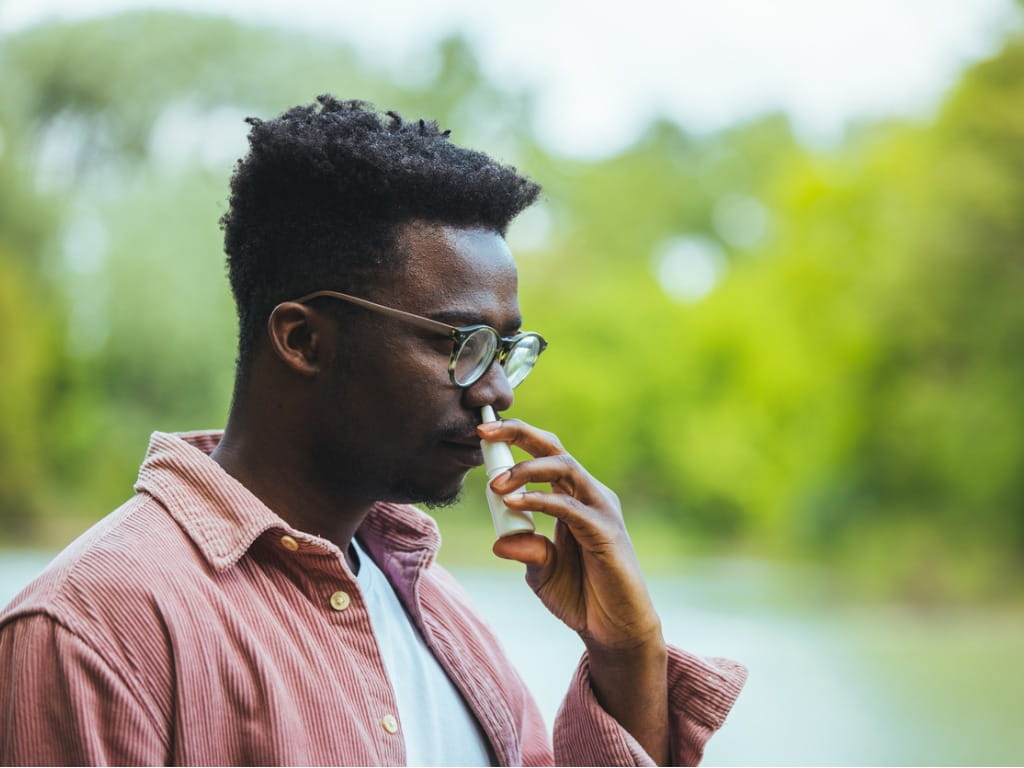 man using nasal spray