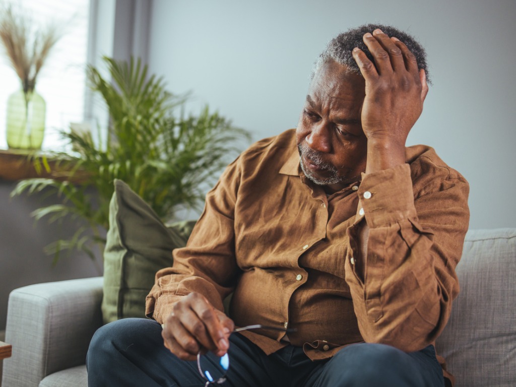 man with depression resting his head in his hand