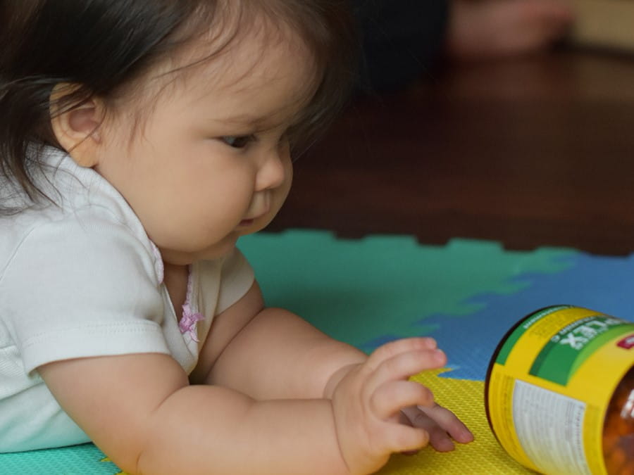 distracted play time baby reaching for bottle of medicine