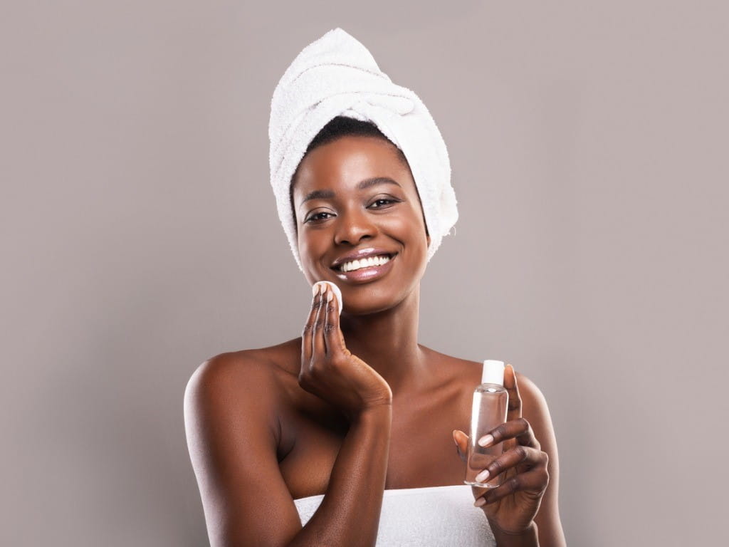 woman washing her face with micellar water