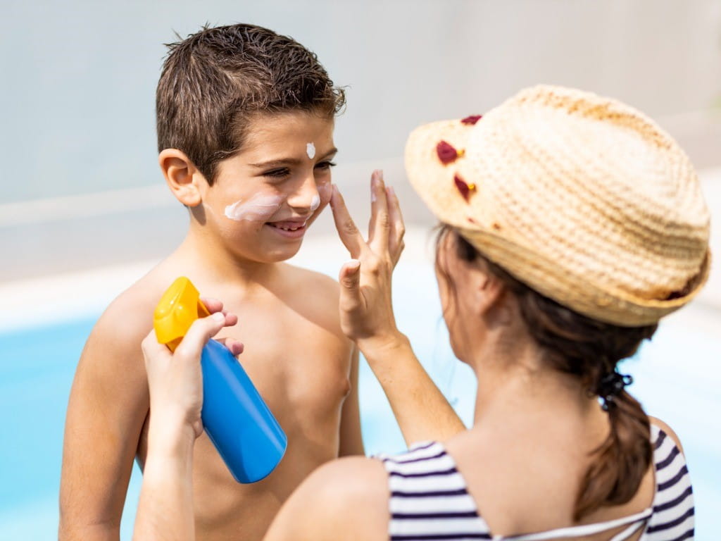 photoallergic dermatitis mother applying sunscreen to son