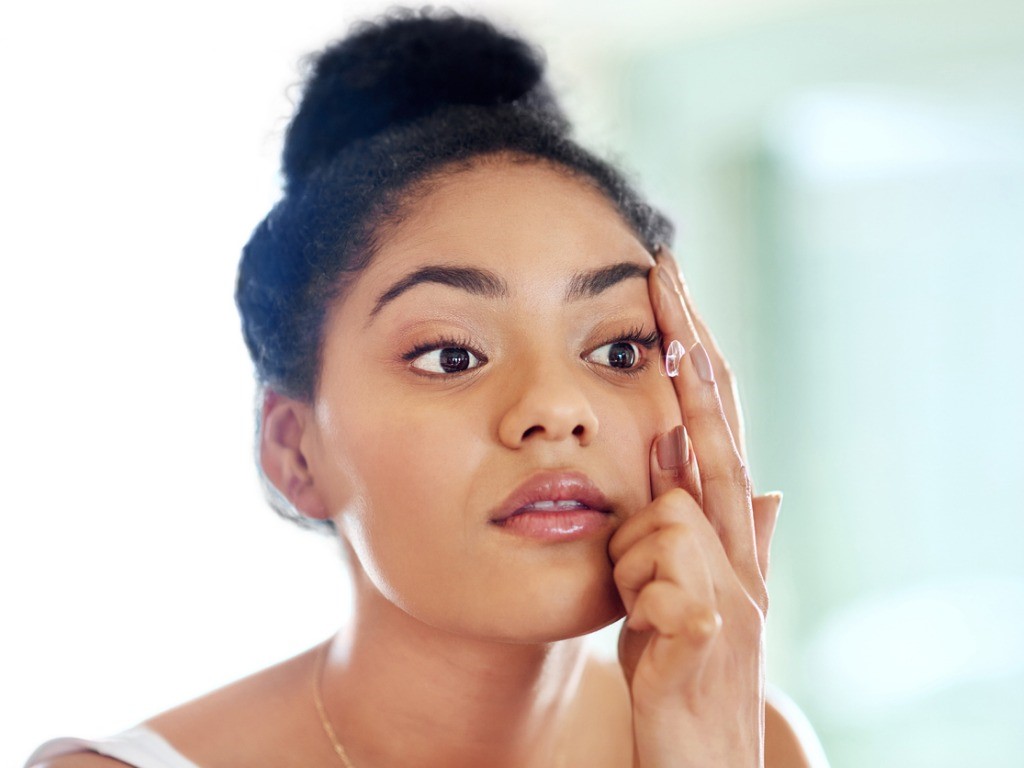 woman inserting contact lenses with povidone