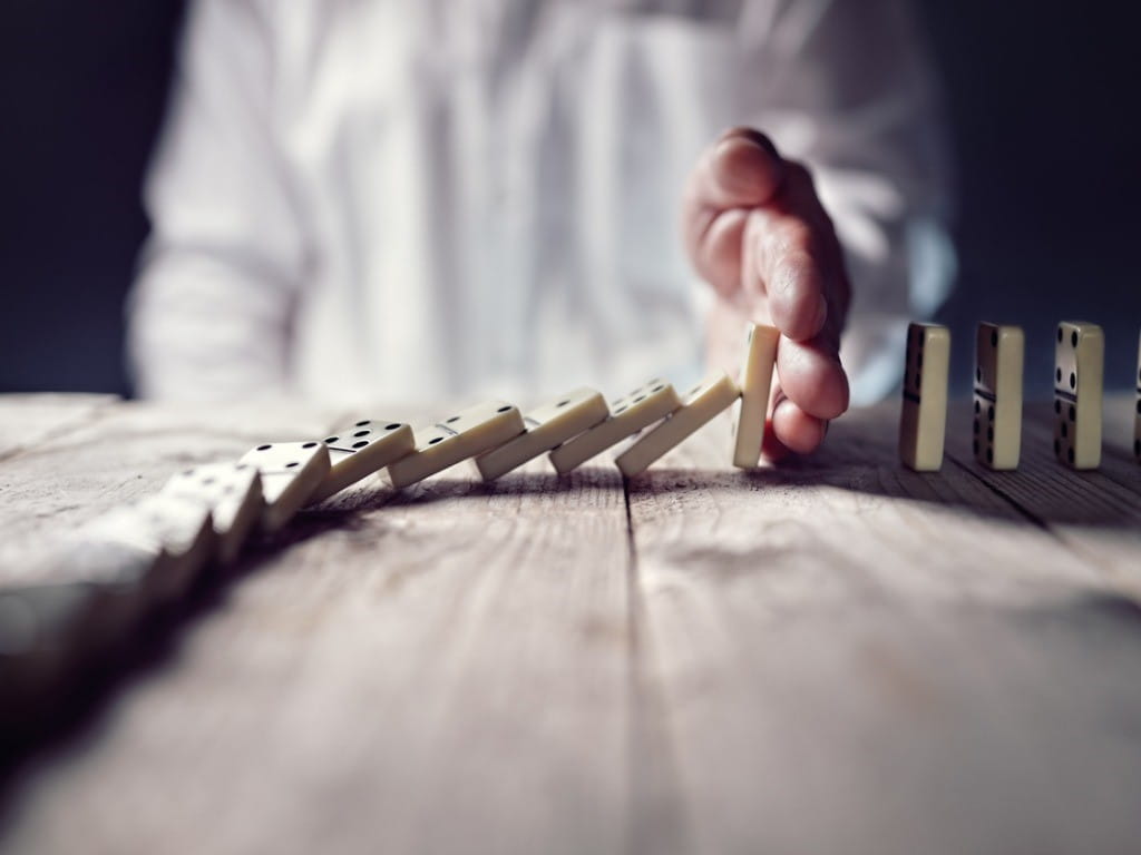 stopping the opioid epidemic man stops falling dominoes with hand