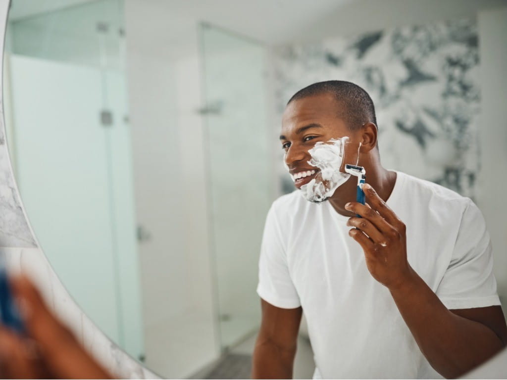 styptic pencil man shaving in mirror