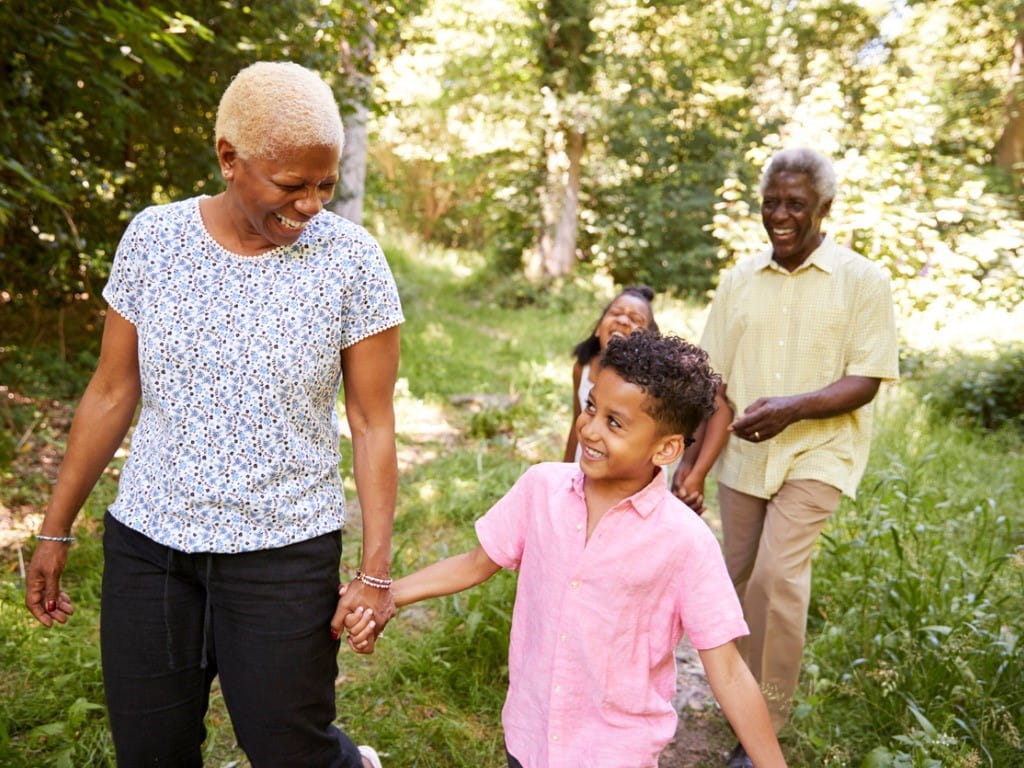 tick borne diseases senior couple walking in forest with grandchildren