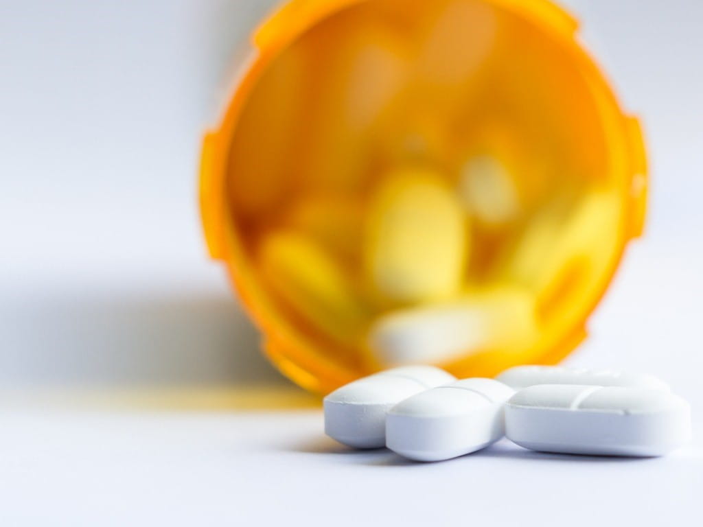 opioid pain medication orange bottle white pills spilled