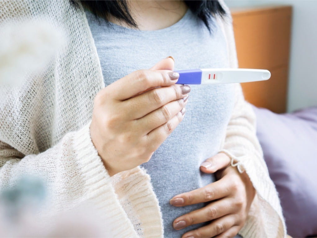 woman holding a positive pregnancy test