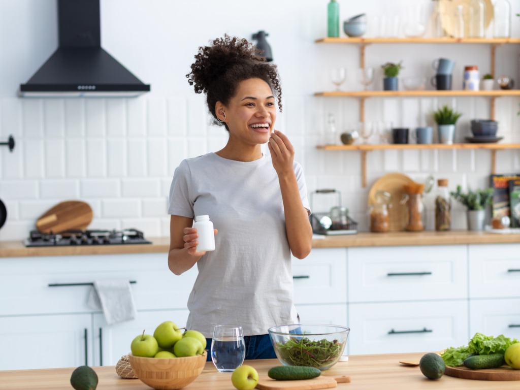 woman taking medicine before eating